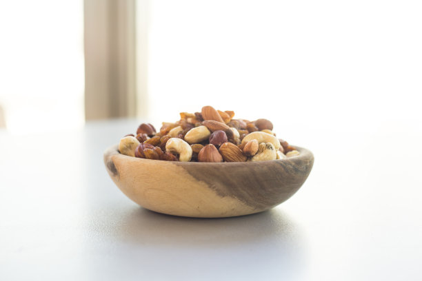 照片的不同类型的坚果在一个盘子在一个灰色的桌子上图片下载