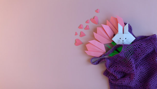 粉红色的郁金香纸在一个紫色的环保袋在粉红色的背景。春天的装饰。生态理念，假日零浪费。带有文本空间的横幅图片下载