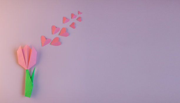 粉色背景上的粉色郁金香和粉色心形纸。春天的装饰，孩子的DIY，妈妈的贺卡。节日的概念。带有文本空间的横幅图片下载