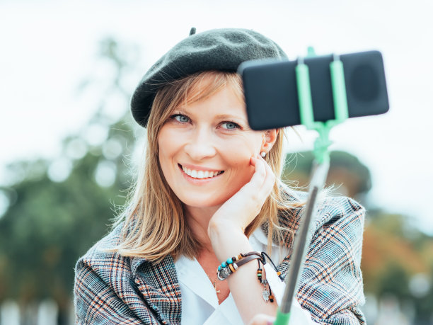 戴法国帽子的白人女孩用自拍杆自拍图片下载