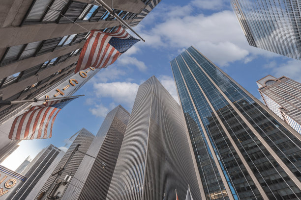 低角度拍摄的摩天大楼与美国国旗在曼哈顿，纽约图片下载