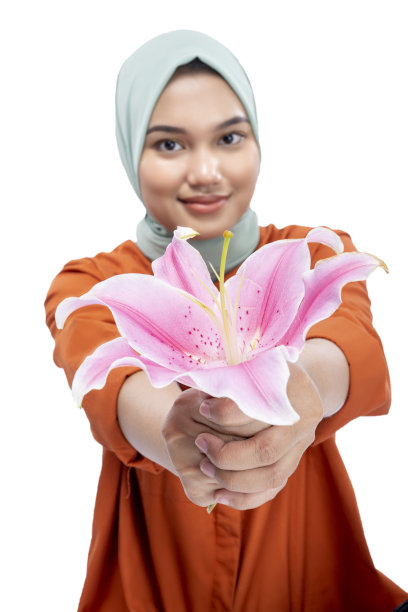 戴着头巾，手持百合花的亚洲穆斯林女性图片下载