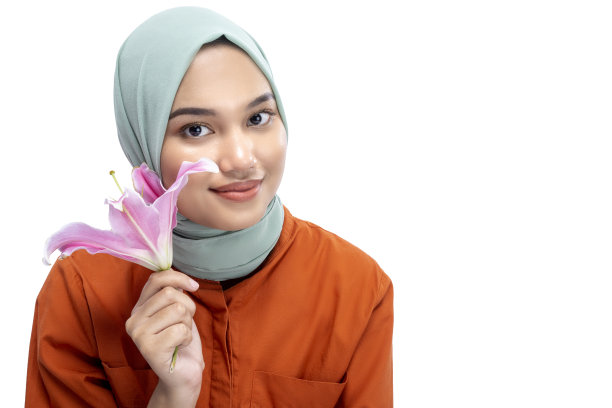 戴着头巾，手持百合花的亚洲穆斯林女性图片下载