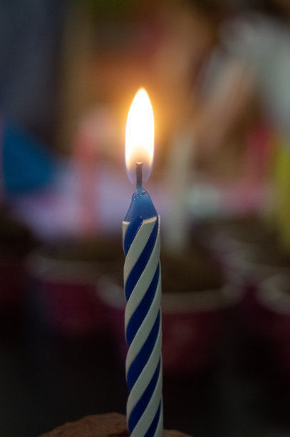 蓝色和白色生日蜡烛的选择性特写图片下载