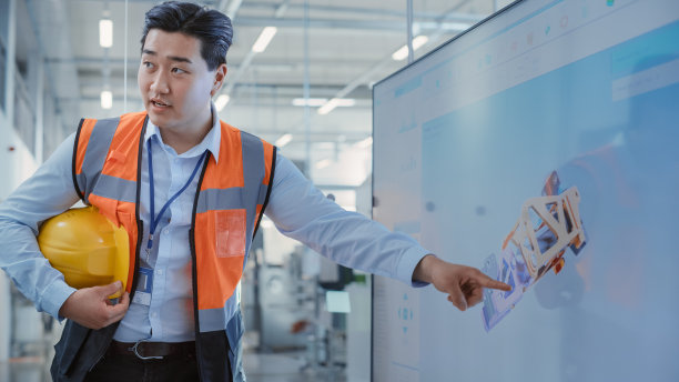 工厂办公室会议:总工程师在有电视的会议室向公司总经理讲解重工业液压件生产新工作流程。在屏幕上显示3D布局。图片下载