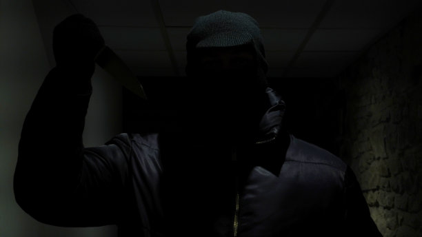 一个男人在黑暗的走廊里持刀图片下载