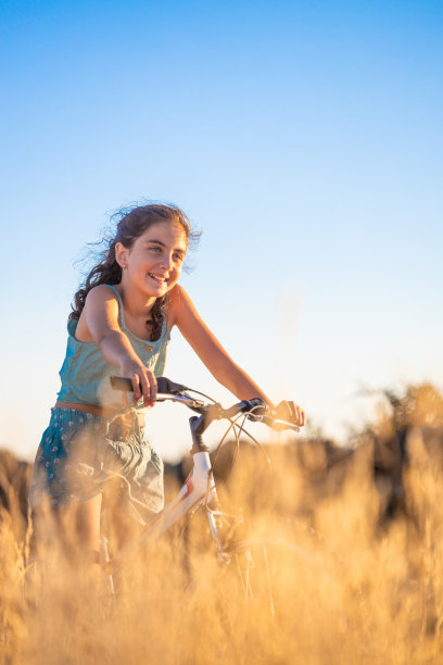 可爱的女孩和她的自行车在夏天。图片下载