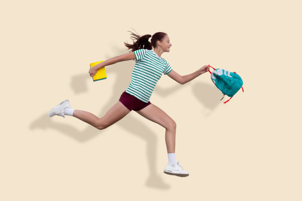 一个十几岁的女孩跑去上学。在背包和笔记本的手里。纯米色背景图片下载