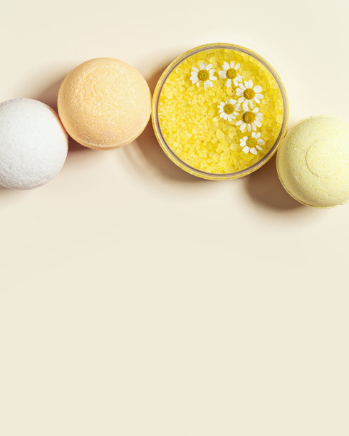 浴盐海与洋甘菊草药提取物，浴炸弹，天然海盐晶体在圆罐和洋甘菊花。香薰中药、身体护理化妆品、平铺图片下载