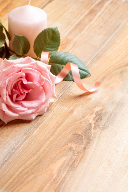 浪漫的节日形象桃色玫瑰，彩带，蜡烛对角木板。副本的空间。图片下载