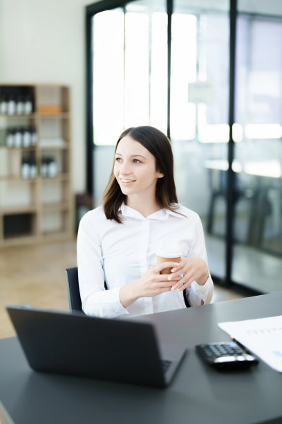 女商人坐着喝咖啡，笑得很开心图片下载