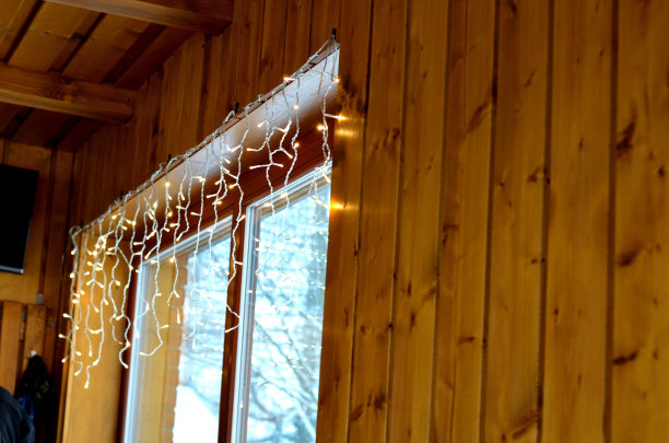 木制小屋窗户上方的Led灯链装饰。圣诞节的心情消耗了很多能量。山上的饭店。图片下载