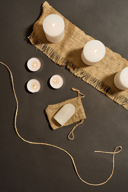 燃烧的蜡烛，除臭剂和黑色麻袋图片下载