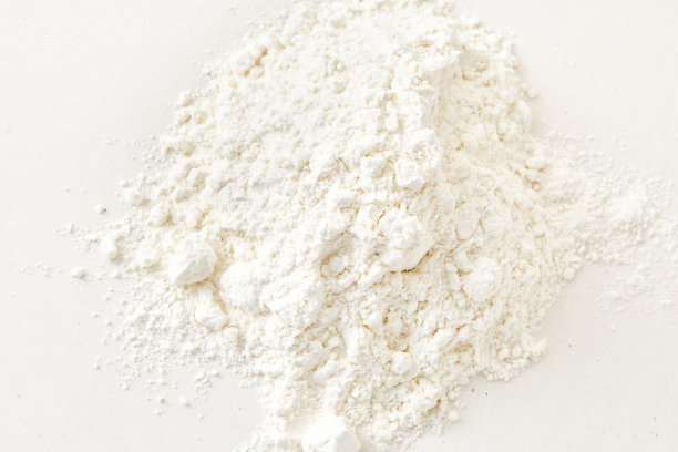 面粉封闭背景。白色背景上的一堆面粉。洒了面粉。面粉的纹理图片下载
