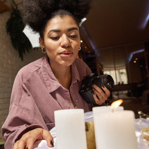 摄影师在相机上拍摄燃烧蜡烛的照片图片下载