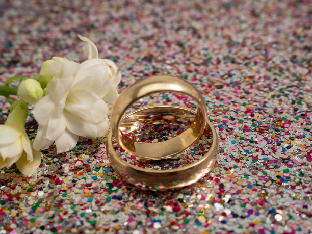 闪闪发光的背景上是结婚戒指。黄金戒指。图片下载