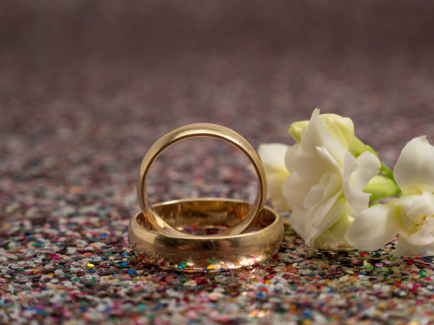 闪闪发光的背景上是结婚戒指。黄金戒指。图片下载