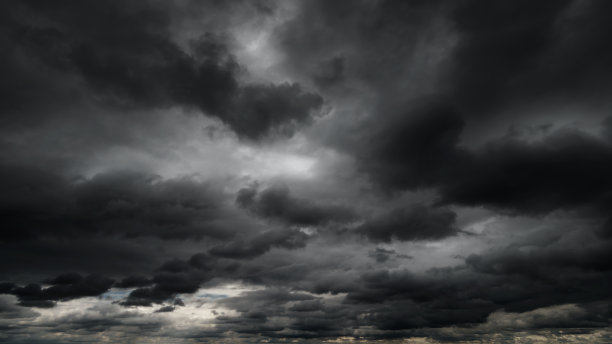 黑色戏剧性的天空，雨雪前的黑色暴风雨云作为抽象背景，极端天气，太阳透过云层，高对比度照片图片下载
