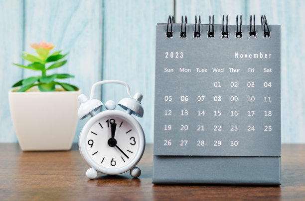 2023年11月的2023年每月台历，蓝色木制背景闹钟。图片下载
