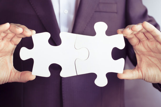 商人连接拼图。男人手里拿着两个空白的白色拼图。业务解决方案，成功和战略概念。图片下载