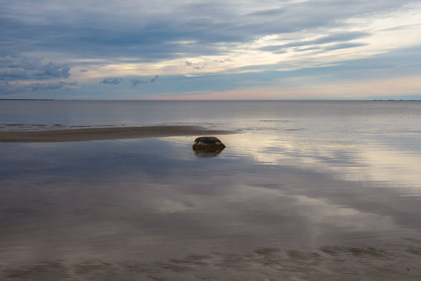 天空中浓密的云覆盖着平静的海面，反射着阳光。简约的照片图片下载