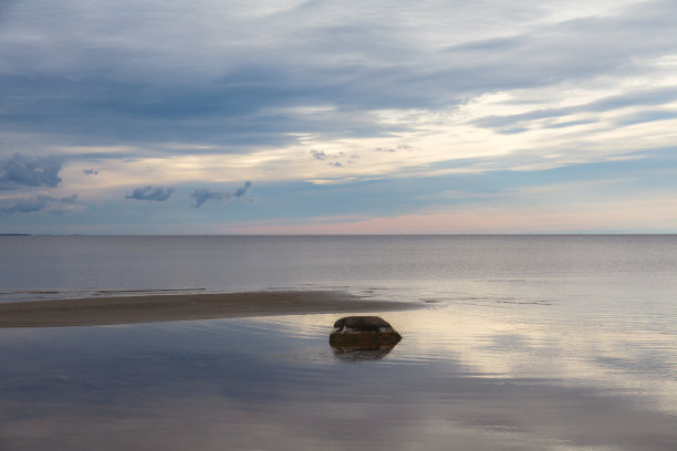天空中浓密的云覆盖着平静的海面，反射着阳光。简约的照片图片下载