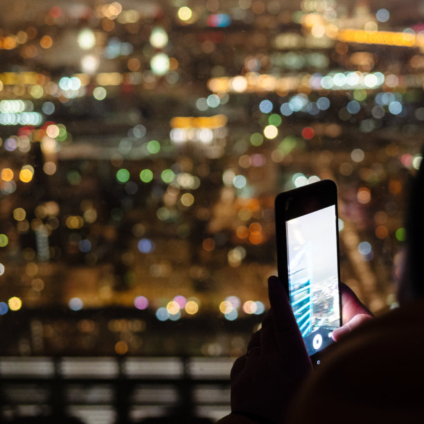 游客用智能手机拍摄夜城图片下载