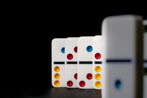 多米诺骨牌游戏。黑色桌子上的多米诺骨牌图片下载