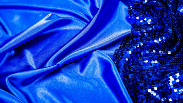 时尚博客的概念。蓝色缎子或丝质织物，以亮片为背景。闪闪发光的质感是本季的流行趋势。闪闪发光的蓝色。工作室的纹理背景。图片下载