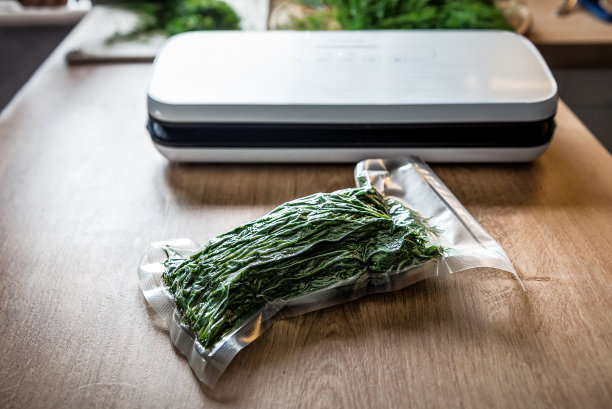 用真空封口机将小茴香装入塑料袋。真空。图片下载