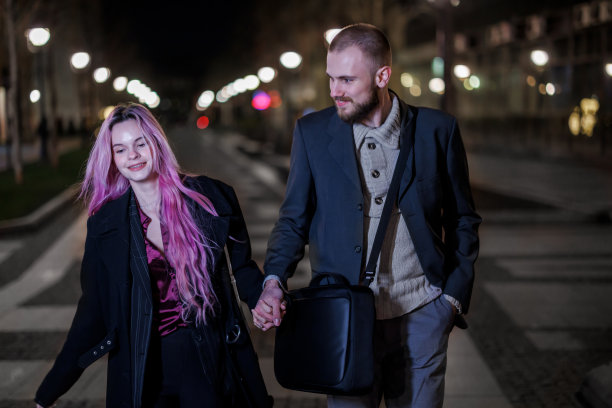 一对时髦的年轻夫妇在城市的夜游中享受着。图片下载