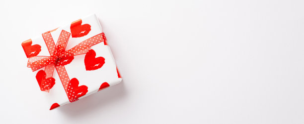 情人节的概念。俯视图照片的时尚礼盒包装与心形图案和丝带蝴蝶结孤立的白色背景与复制空间图片下载