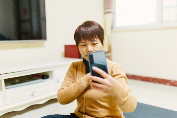 一位中年妇女用手机自拍——科技与生活，简单的生活方式图片下载