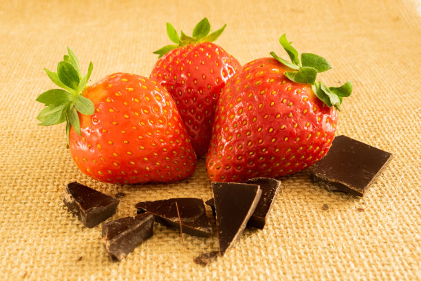 新鲜美味的草莓和切碎的黑巧克力在纺织背景图片下载