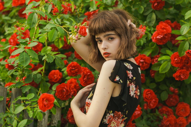 红头发的模型背景上的玫瑰灌木图片下载