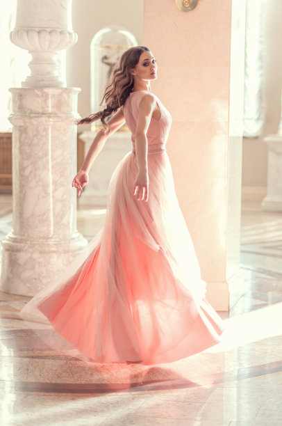 美丽的女孩在一个长透明的粉红色连衣裙。芭蕾舞女演员足尖舞，在豪华的室内与美丽的光线从窗户图片下载