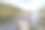一个女人坐在湖边的岩石上，用笔记本电脑远程工作图片下载