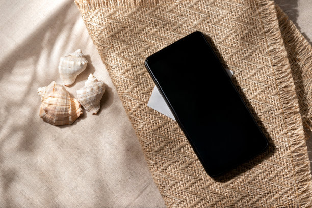 简约的方形审美中性的夏日度假质感。米色纺织品背景上的贝壳特写视图。图片下载