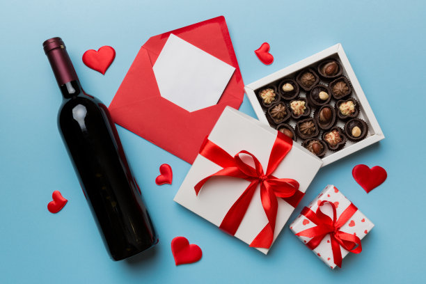 情人节彩色背景红酒，礼盒，信封和巧克力。心形的礼盒巧克力顶部视图与复制空间图片下载