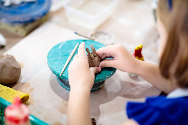 在陶轮旁的孩子。儿童工艺品班图片下载