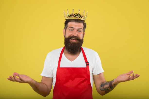 厨房是我的王国。烹饪时以胡子和小胡子为黄色背景。皇家的配方。男人国王厨师穿着做饭围裙和金色的皇冠。想法和技巧。厨师长，专业烹饪。烹饪食物图片下载