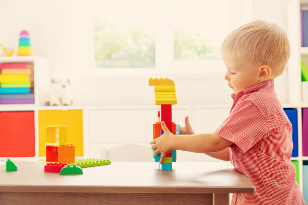 可爱的孩子坐在桌子上玩构造器。图片下载