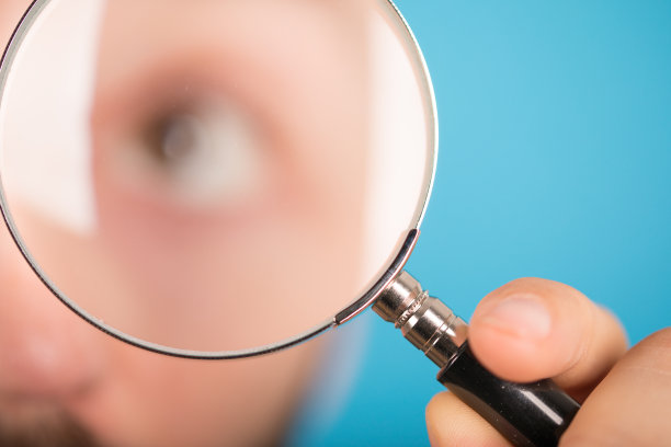 放大镜在模糊背景上的特写镜头图片下载