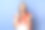 照片中欢快的年轻女子穿着白色t恤和橙色毛衣系在肩膀上，站在蓝色背景上，享受着热水瓶里美味的咖啡，快乐地笑着。图片下载