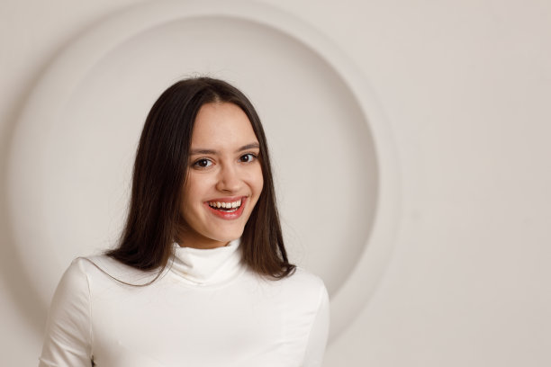 室内肖像积极微笑黑发年轻女子在白色背景图片下载