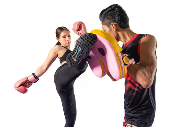 亚洲美丽的年轻女子锻炼与教练在拳击手套和自卫课打拳，女性自由搏击训练与男性教练在健身馆战斗。锻炼健康的运动理念图片下载