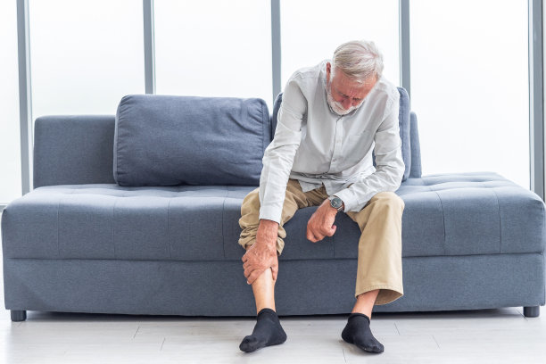 保健和问题概念。不开心的老人在家里忍受膝盖疼痛。膝关节损伤。痛风。类风湿。关节炎。骨质疏松症图片下载