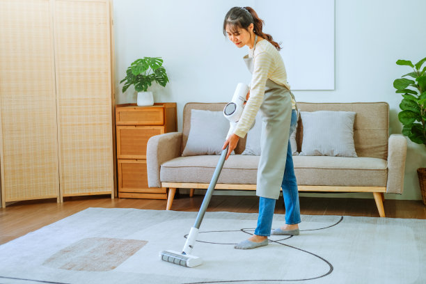 亚洲妇女用真空吸尘器清洁地板。管理的概念图片下载