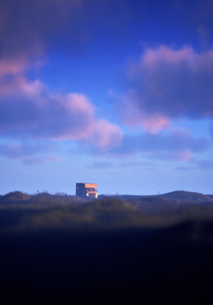 在多云的天空下，夕阳下连绵起伏的乡村，汽车之家亮着大灯。3 d渲染。图片下载