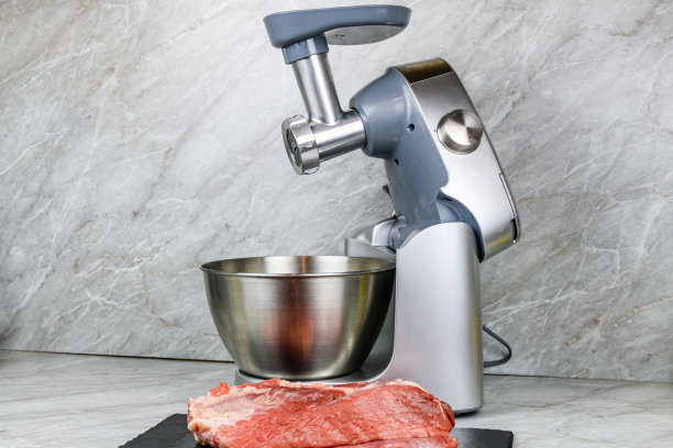 现代食品加工机与绞肉机和和平的猪肉在厨房桌子上图片下载